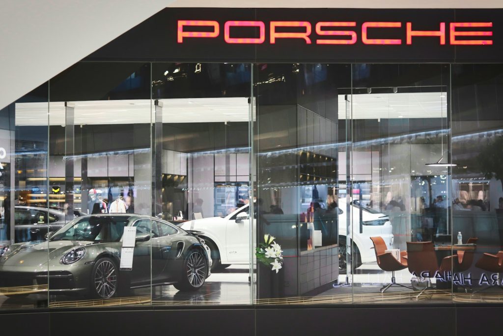 a porsche dealership with a car parked in front of it