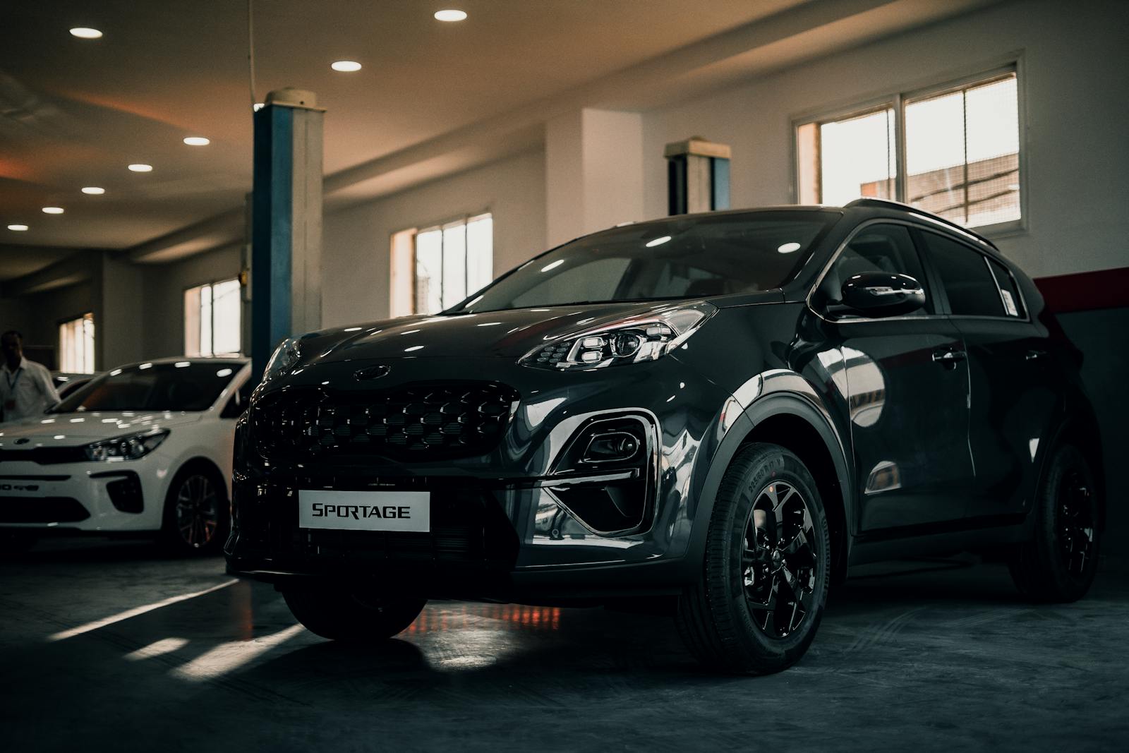 Kia Sportage parked indoors in a stylish garage, showcasing sleek design and glossy finish.